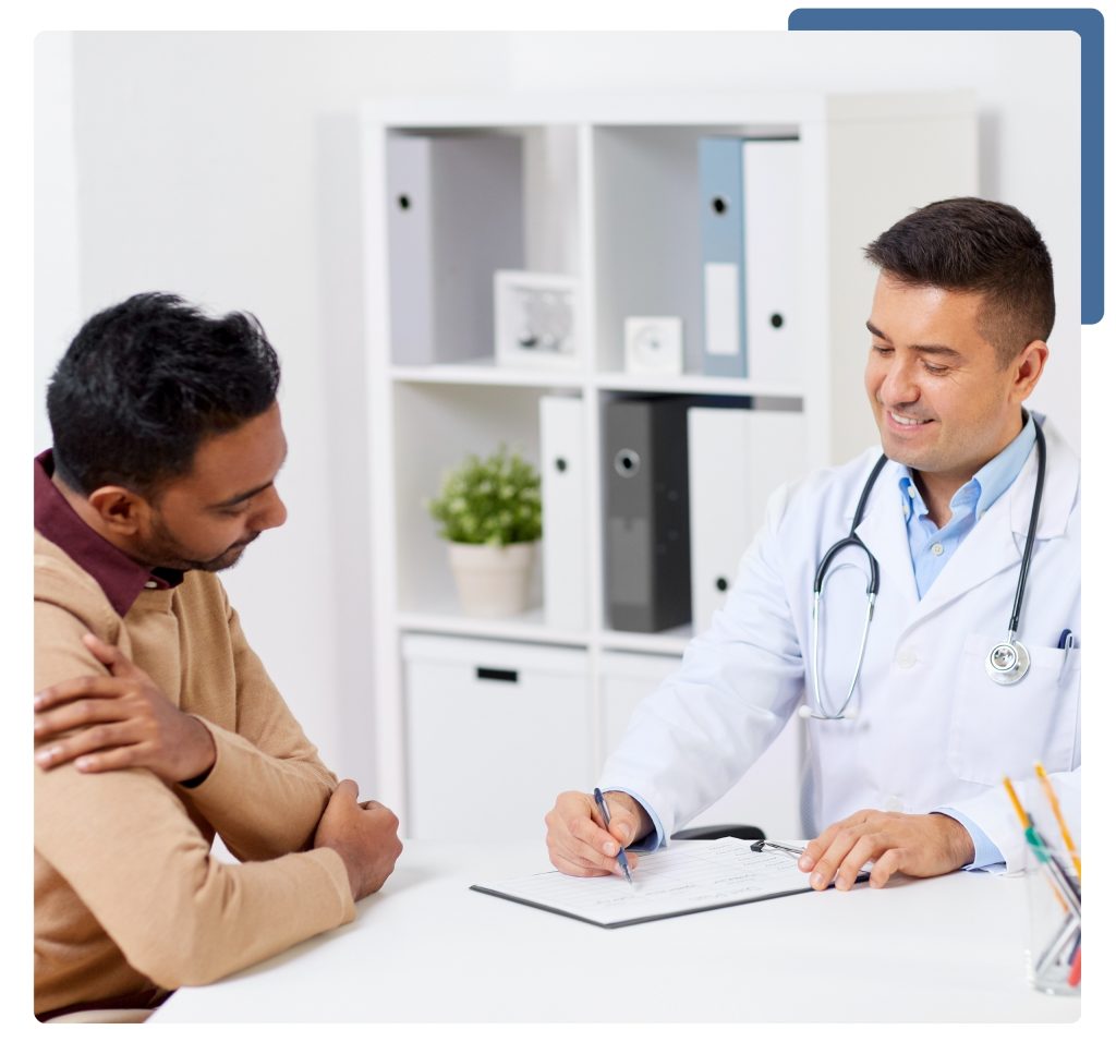 A doctor's office featuring a patient seated in a chair while a physician reviews medical notes at a desk.